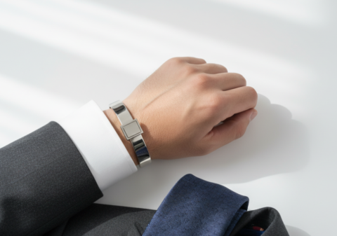 Silver cufflinks on white French cuff with navy tie and dark suit